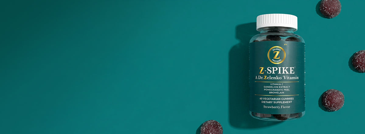 Bottle of Z-Spike with gummies around it on teal background