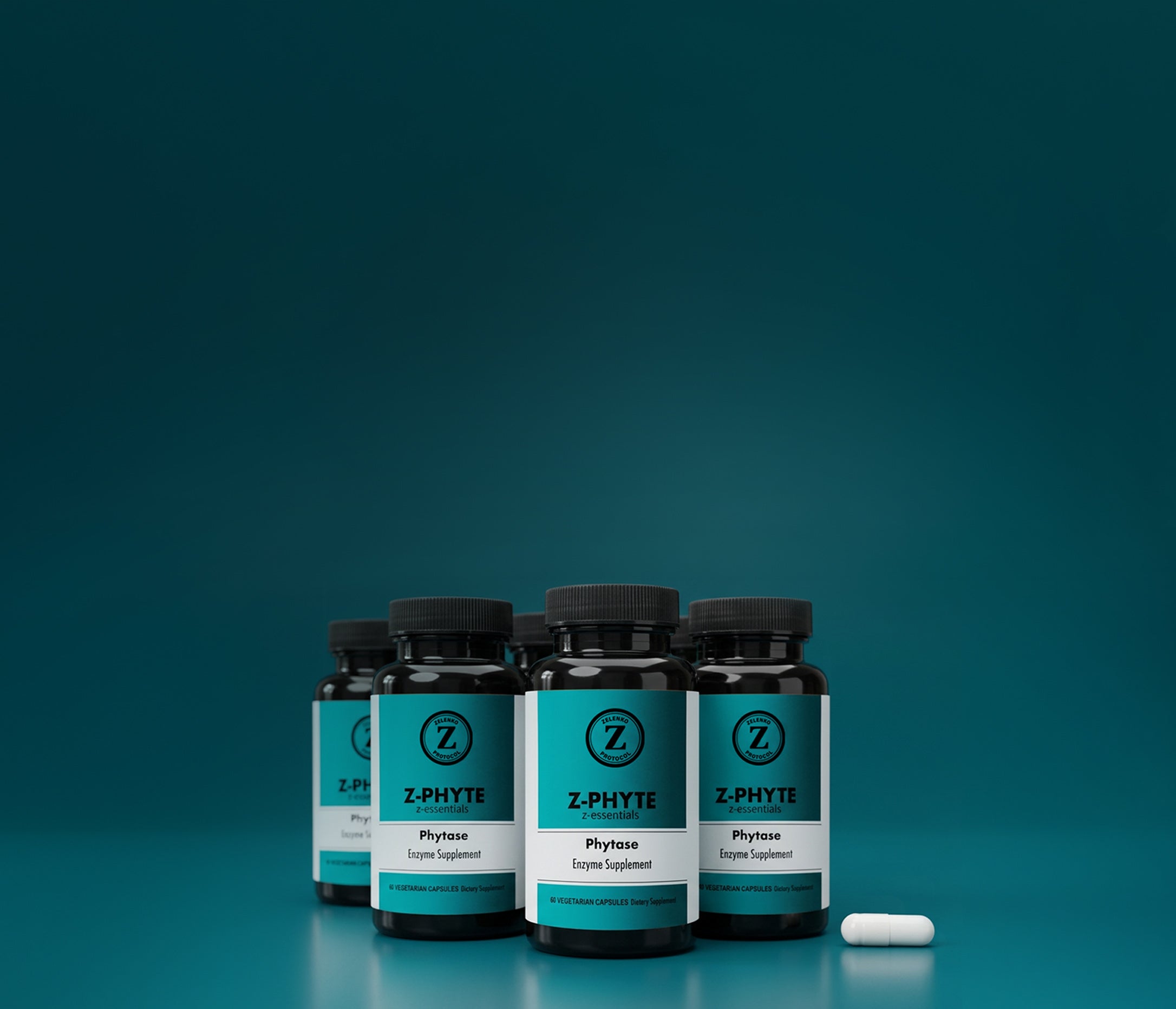 Four black supplement bottles with teal and white Z-Phyte labels are arranged in a row on a teal gradient background, with a single white capsule lying beside them.