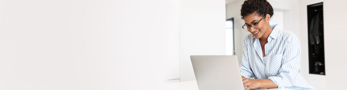Lady on a laptop in a white kitchen